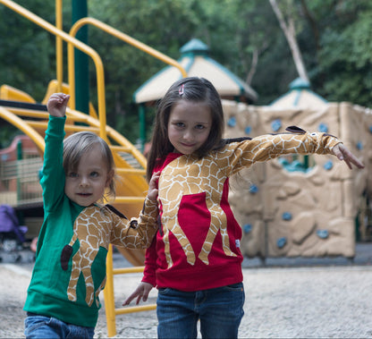Kinder mit Luanimals Giraffe Gerda in rot und grün auf dem Spielplatz