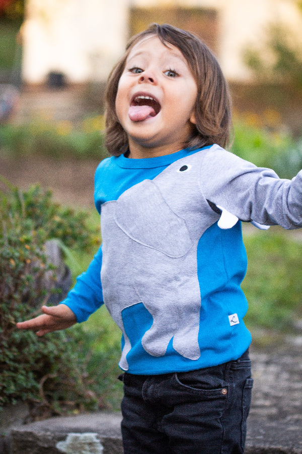 Ein glückliches Kind mit einem Pullover mit Tiermotiv Elefant Eli in blau von Luanimals 